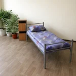 Одноярусная кровать КО1 в комнате общежития с матрасом и тумбой